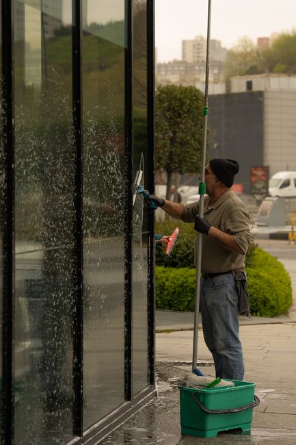 Nettoyage de la vitrine d'un commerce à la raclette, côté rue
